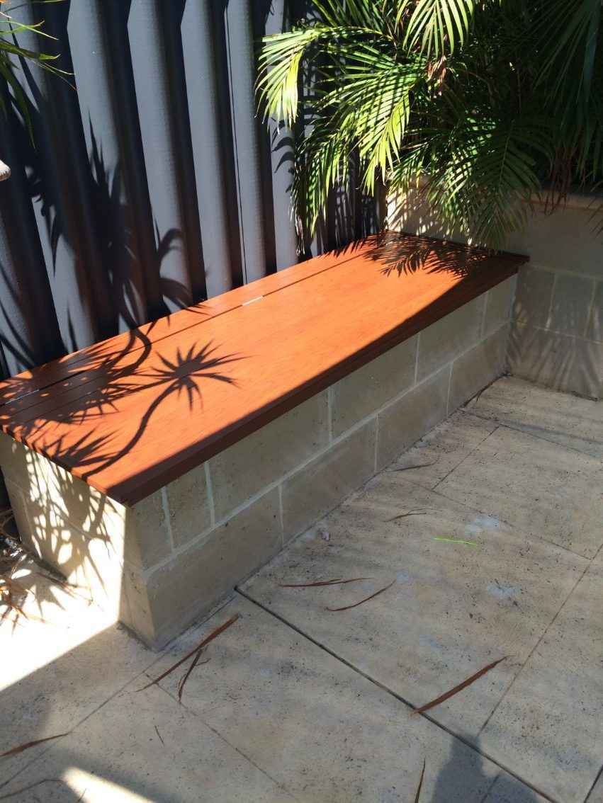 Brown pool cover box that is converted into a seat.