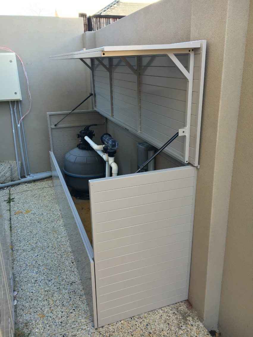Brown filter pump enclosure box against a brown wall.