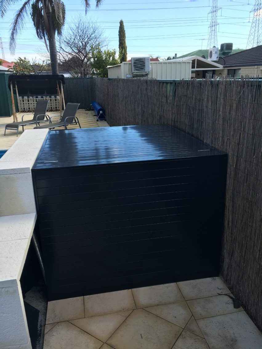 Black pool pump box next to the swimming pool