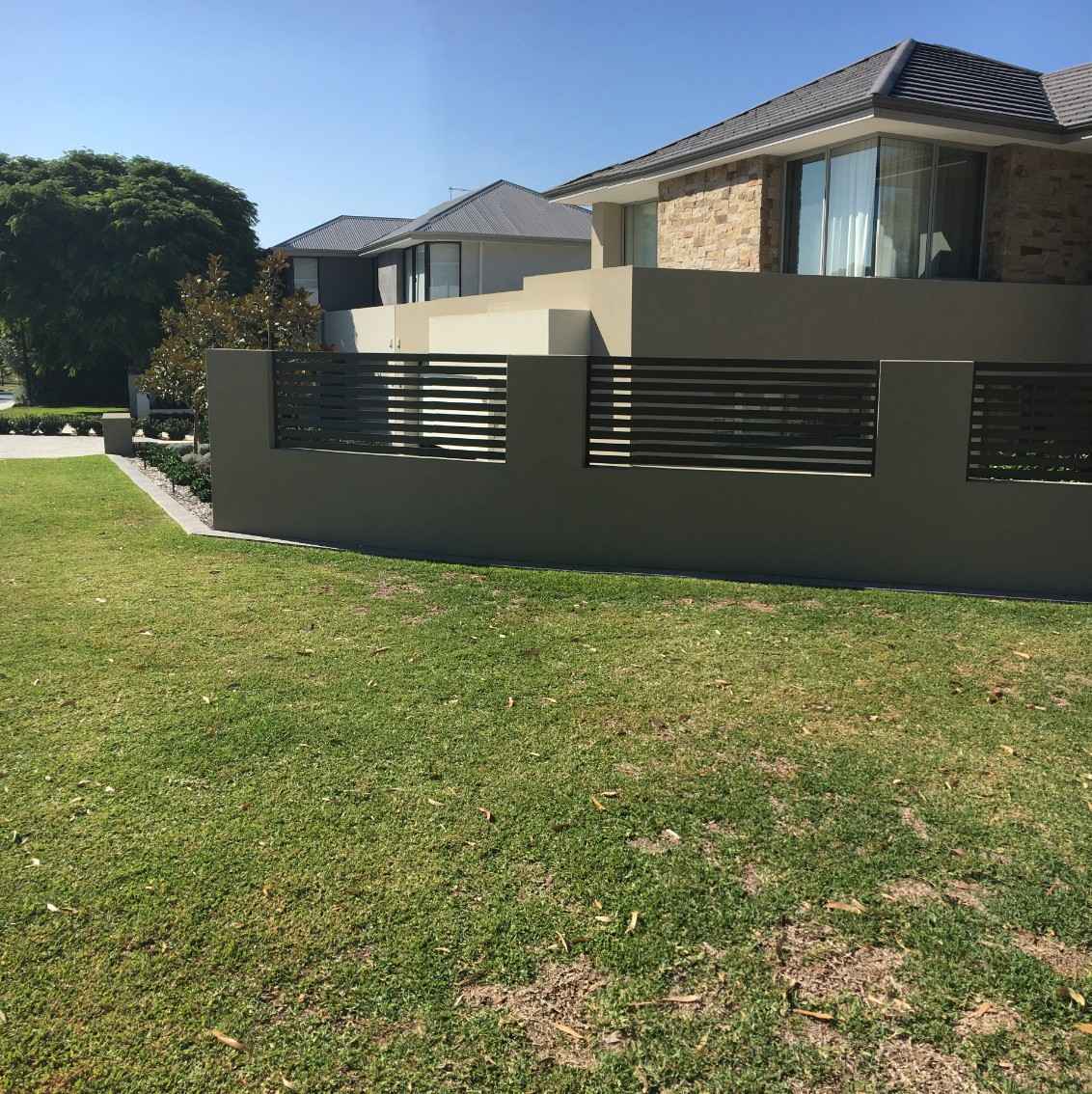 Light brown wall and dark brown wooden pool fence installation