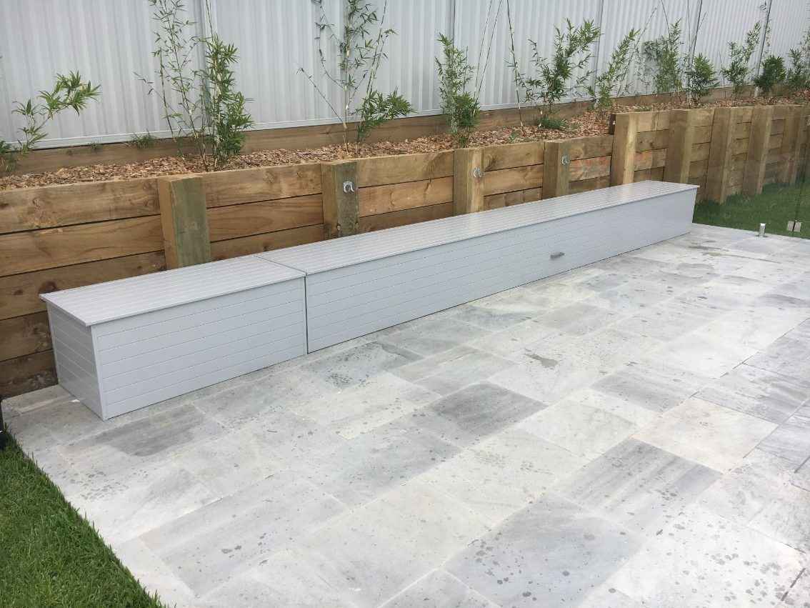 Gray pool cover box against a garden backdrop